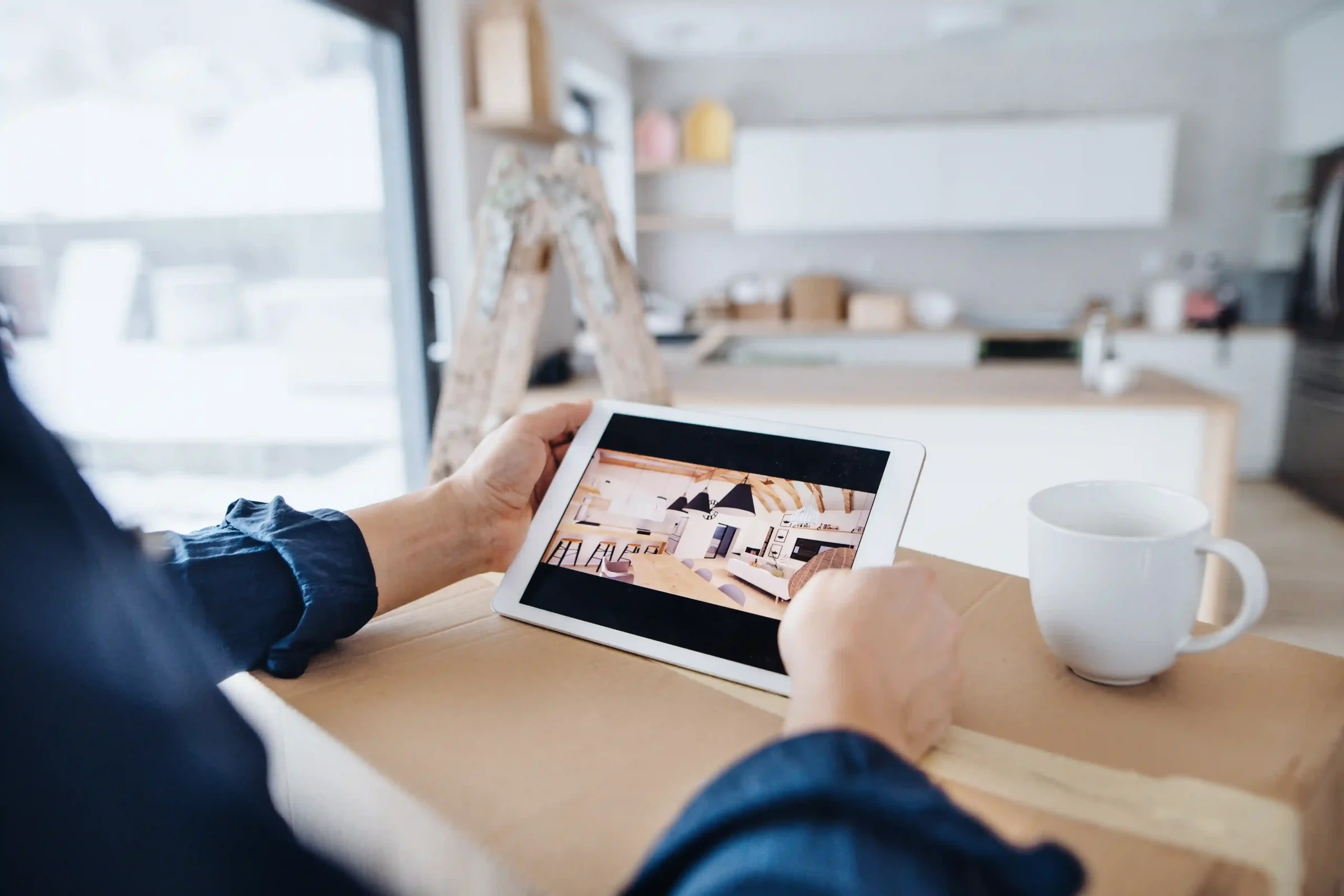 Person viewing design ideas on tablet in kitchen