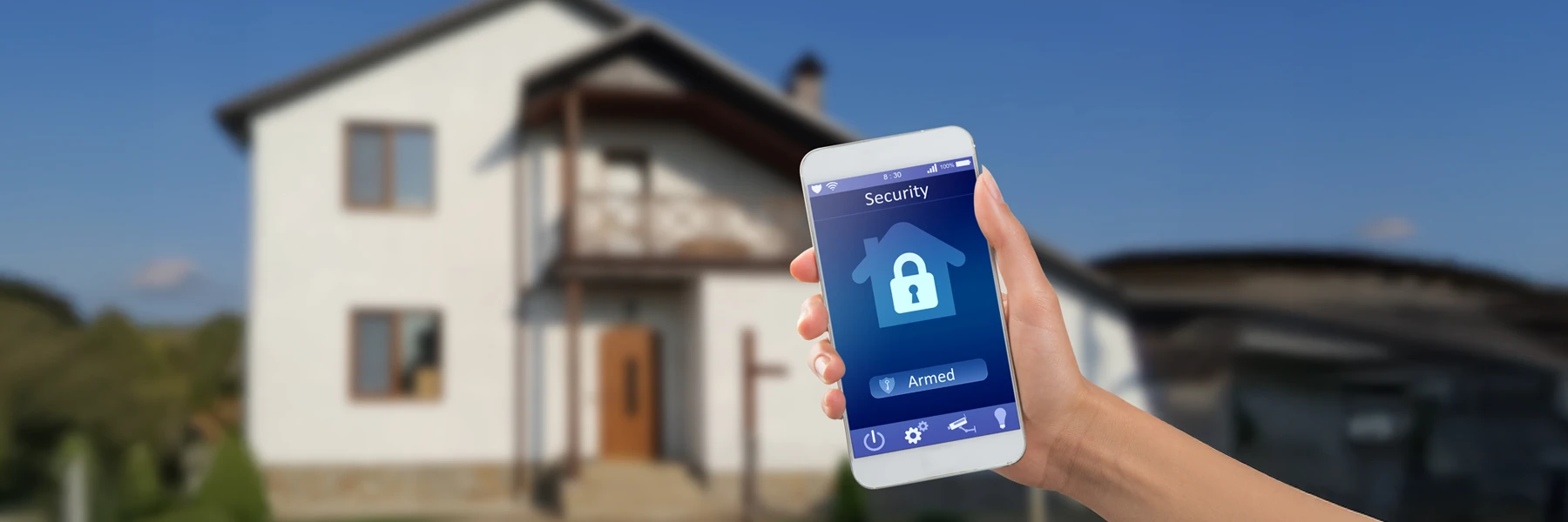 Smartphone controlling home security system outside house