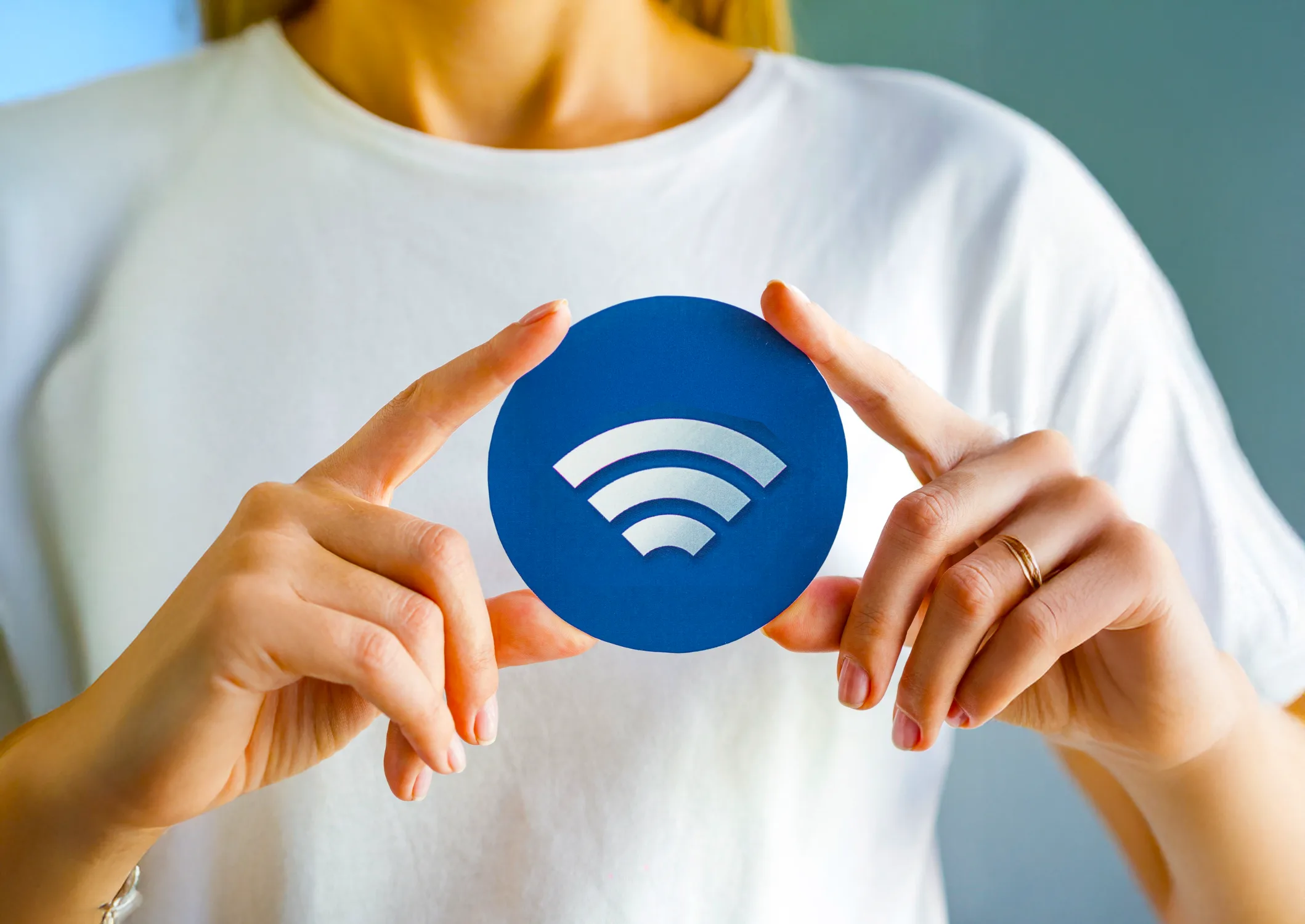 Person holding a blue Wi-Fi symbol disc