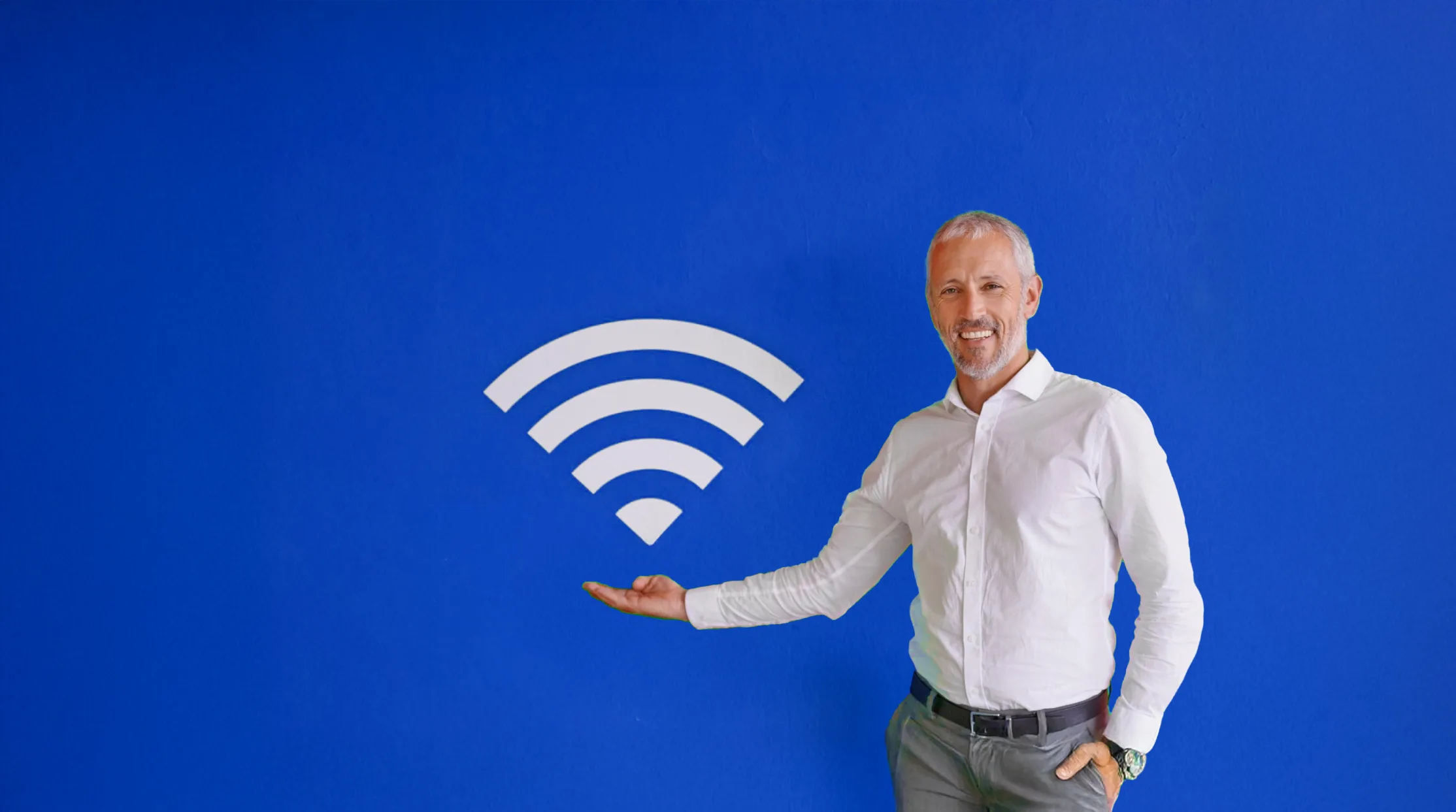 Smiling man gesturing toward Wi-Fi symbol.