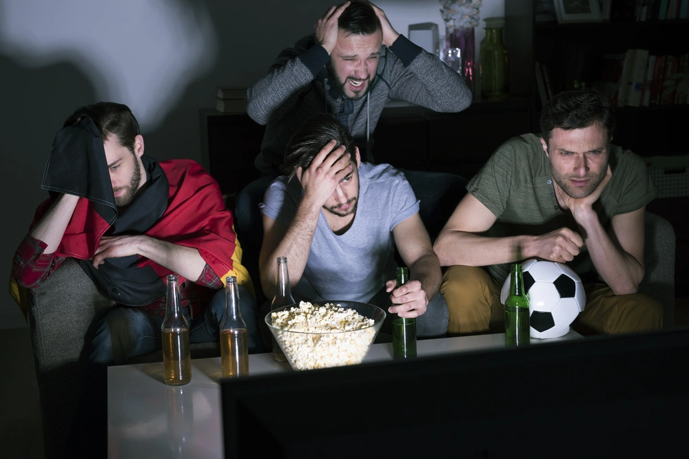 Four friends anxiously watching a sports game.