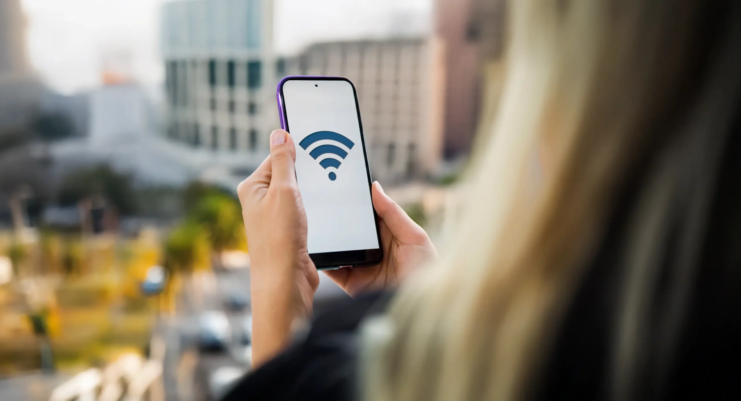 Person holding phone displaying Wi-Fi symbol